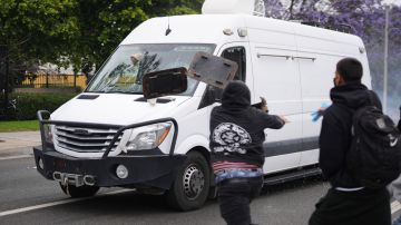 Protesters throw objects as law enforcement drive a van past during a protest in Paramount, Calif., Saturday, June 7, 2025, after federal immigration authorities conducted operations. (AP Photo/Eric Thayer)