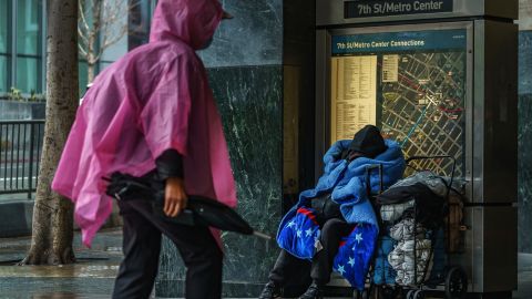 A homeless person covers up with a blanket outside the entrance to the 7th Street/Metro Center subway station in downtown Los Angeles Friday, March 19, 2023. California is bracing with an atmospheric river that forecasters warn will bring heavy rain, strong winds, thunderstorms and the threat of flooding even as the state is still digging out from earlier storms. (AP Photo/Damian Dovarganes)