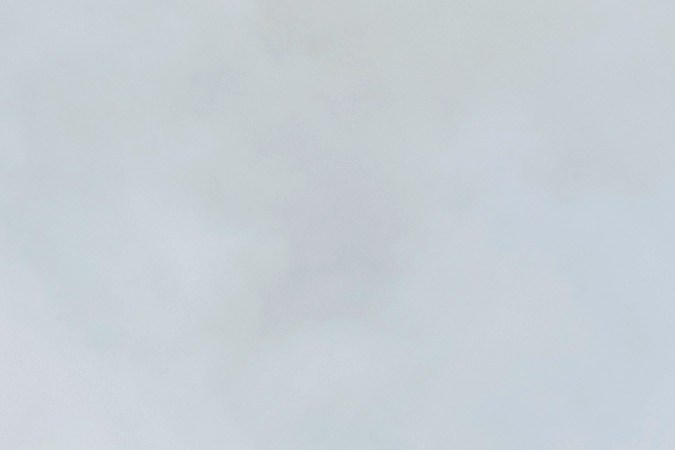 Un manifestante camina entre gases lacrimógenos disparados por agentes federales durante un enfrentamiento cerca de un Home Depot después de una redada de ICE en Paramount, California.