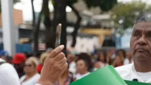 Una venezolana en una marcha en Caracas con la bandera de su país y la de Irán.