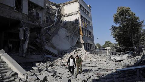 Dos hombres caminan entre los escombros de un edificio destruido por un ataque aéreo israelí en Damasco, la capital siria.