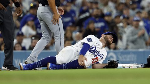 Los Angeles Dodgers' Max Muncy holds his knee after tagging out Chicago White Sox's Michael A. Taylor attempting to steal third base during the during the sixth inning Wednesday, July 2, 2025, in Los Angeles. (AP Photo/Kevork Djansezian)