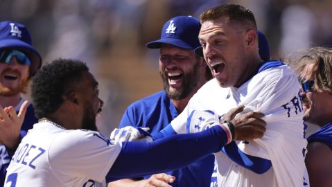 Freddie Freeman (der.) es felicitado por Teoscar Hernández, Clayton Kershaw y otros de sus compañeros luego de batear el hit del triunfo para los Dodgers en la novena entrada contra Minnesota.