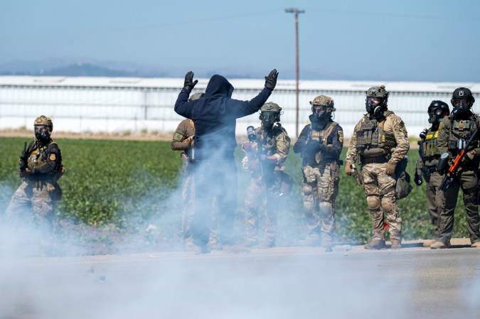 Federal immigration agents toss tear gas at protesters during a raid in the agriculture area of Camarillo, Calif., Thursday, July 10, 2025. (AP Photo/Michael Owen Baker)