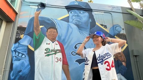 Vivian Valenzuela, aficionada de los Dodgers, posa delante del nuevo mural dedicado a la memoria de Fernando Valenzuela en Dodger Stadium.