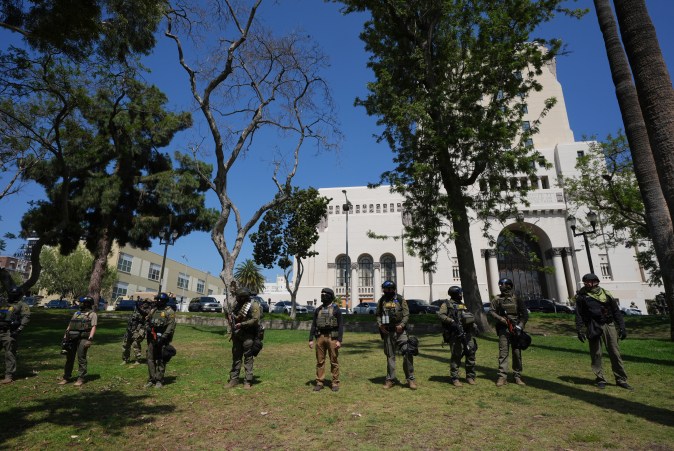 Federal agents stage at MacArthur Park Monday, July 7, 2025, in Los Angeles. (AP Photo/Damian Dovarganes)