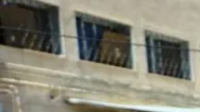 Un médico y otros hombres caminan junto a los cadáveres de los muertos en los combates en un hospital de la ciudad de Sweida.