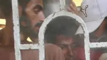 Varios palestinos se agolpan para recibir una comida caliente en un comedor social, al sur de la Franja de Gaza.