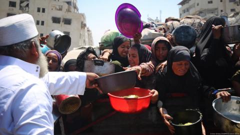 Palestinos esperan para recibir comida en un comedor social.
