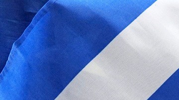 Las banderas de de EE.UU., Haití, Venezuela y Cuba durante una conferencia de prensa sobre la protección humanitaria a más de 500,000 inmigrantes.
