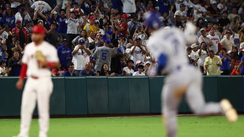 Fans cheer as Los Angeles Dodgers designated hitter Shohei Ohtani gestures while running the bases after hitting a home run and Los Angeles Angels third baseman Yoán Moncada looks on during the eighth inning of a baseball game, Monday, Aug. 11, 2025, in Anaheim, Calif. (AP Photo/Jessie Alcheh)