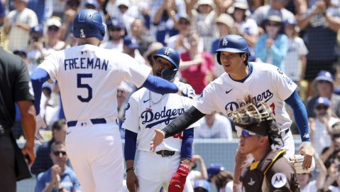 Los Angeles Dodgers' Freddie Freeman, left, is congratulated by Mookie Betts, center, and Shohei Ohtani after hitting a three-run home run against San Diego Padres pitcher Yu Darvish during the first inning of a baseball game, Sunday, Aug. 17, 2025, in Los Angeles. (AP Photo/Kevork Djansezian)