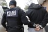In this photo made Thursday, March 6, 2015, a U.S. Immigration and Customs Enforcement agent escorts a handcuffed undocumented immigrant convicted of a felony that was taken into custody during an early morning operation in Dallas. The Department of Homeland Security has been conducting a nationwide roundup of undocumented immigrants convicted of felonies in order to deport them to their country of origin. (AP Photo/LM Otero)