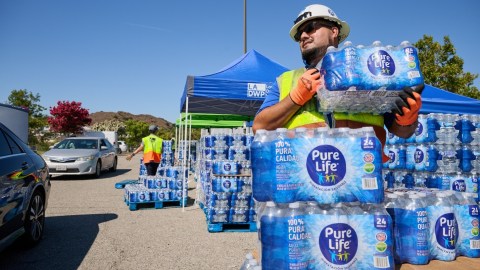 Trabajadores del Departamento de Agua y Luz de Los Ángeles reparten botellas de agua a los vecinos afectados.