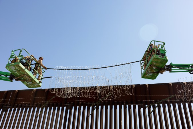 Marines colocan alambre de concertina en la barrera fronteriza existente en Yuma, Arizona, el 11 de agosto de 2025.