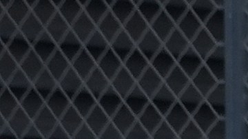 Department of Homeland Security (DHS) agents guard the entrance to the federal building adjacent to the Metropolitan Detention Center as protesters stand by in Los Angeles, Tuesday, July 15, 2025. (AP Photo/Damian Dovarganes)