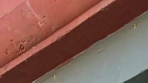 Connie Valencia al lado del cartel que anuncia Fernandomanía, una serie de obras inspiradas en el pelotero Fernando Valenzuela.