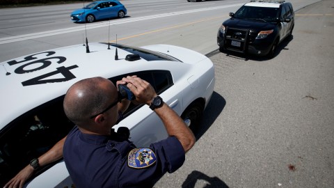 California Highway Patrol officer Matthew Musselmann uses a lidar gun for speed detection along Interstate 5 freeway, Thursday, April 23, 2020, in Anaheim, Calif. The CHP is issuing a lot more tickets to motorists where lanes are wide open during the coronavirus pandemic. From March 19, when the stay-at-home order began, through April 19, officers issued 87% more citations to drivers suspected of speeding in excess of 100 mph. That's compared to the same period last year. The jump in speeding tickets coincides with a 35% decline in traffic volume. (AP Photo/Chris Carlson)