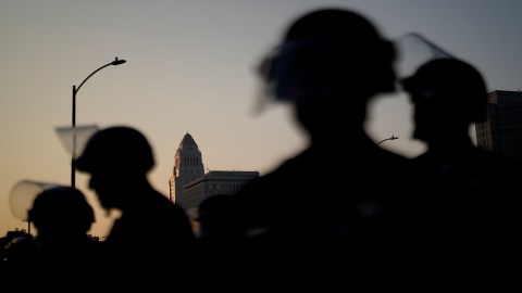Law enforcement officers in riot gear patrol a street near Los Angeles City Hall in downtown Los Angeles on Monday, June 9, 2025. (AP Photo/Eric Thayer)