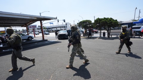 Immigration agents conduct an operation at a car wash on Friday, Aug. 15, 2025, in Montebello, Calif. (AP Photo/Gregory Bull)