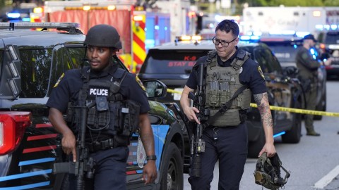 Agentes de policía armados caminan cerca de la escena del tiroteo en la Universidad Emory en Atlanta.
