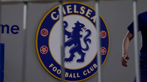 A Chelsea football club logo is displayed with a barrier in the foreground at an entrance to Chelsea's Stamford Bridge stadium in London, Monday, April 18, 2022. The owners of the Chicago Cubs dropped their interest in buying Chelsea, leaving three remaining bids for the enforced sale of the Premier League club by sanctioned Russian owner Roman Abramovich. A New York-based merchant bank, the Raine Group, has been overseeing the sale process that was announced last month by Abramovich following Russia's invasion of Ukraine. (AP Photo/Matt Dunham)