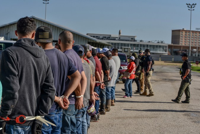 Trabajadores esposados después de ser arrestados por agentes del Servicio de Inmigración y Control de Aduanas de Estados Unidos (ICE por sus iniciales en inglés) en el Hipódromo Delta Downs, el miércoles 18 de junio de 2025, en Calcasieu Parish, cerca de Vinton, Luisiana. (Servicio de Inmigración y Control de Aduanas de Estados Unidos vía AP)