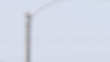 A bystander watches as immigration agents conduct an operation at a car wash on Friday, Aug. 15, 2025, in Montebello, Calif. (AP Photo/Gregory Bull)