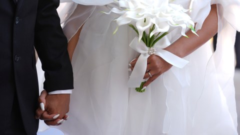 A couple holds hands as they are married in a Valentine's Day group wedding ceremony at the Dade County Courthouse in Miami, Friday, Feb. 14, 2025. (AP Photo/Rebecca Blackwell)