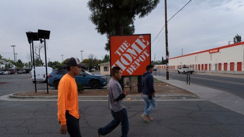 Workers walk toward a food vendor past a Home Depot sign in the Van Nuys section of Los Angeles, Aug. 28, 2025. (AP Photo/Jae C. Hong)