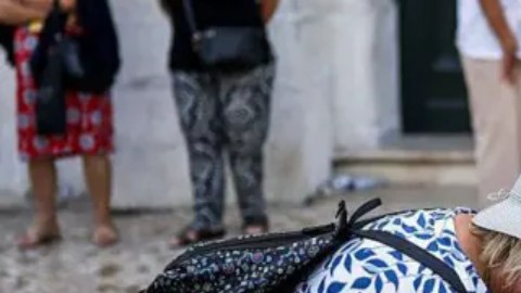 Una mujer coloca flores en el sitio donde ocurrió el accidente en Lisboa.