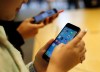 Customers try out a new Apple iPhone 6S at an Apple store on Chicago's Magnificent Mile, Friday, Sept. 25, 2015, in Chicago. (AP Photo/Kiichiro Sato)