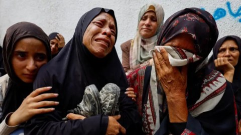 La madre de un adolescente palestino asesinado por fuego israelí llora durante su funeral.