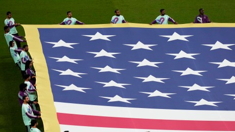 Volunteers hold a flag of the United States on the pitch before the start of the World Cup round of 16 soccer match between the Netherlands and the United States, at the Khalifa International Stadium in Doha, Qatar, Saturday, Dec. 3, 2022. (AP Photo/Luca Bruno)