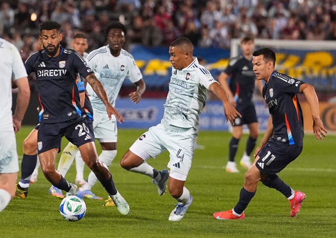 Colorado Rapids defender Reggie Cannon, center, pursues the ball while driving between San Diego FC midfielders Anibal Godoy, left, and Hirving Lozano, right, in the first half of an MLS soccer match Saturday, April 12, 2025, in Commerce City, Colo. (AP Photo/David Zalubowski)