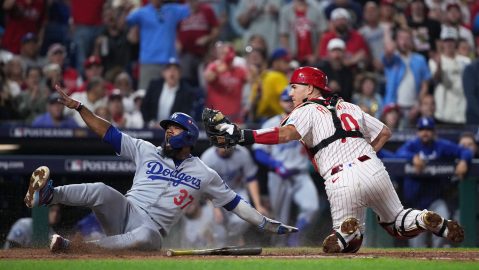Los Angeles Dodgers' Teoscar Hernandez, left, slides home past Philadelphia Phillies catcher J.T. Realmuto to score off a fielder's choice off of a ground ball hit by Kiké Hernández during the seventh inning in Game 2 of baseball's National League Division Series, Monday, Oct. 6, 2025, in Philadelphia. (AP Photo/Matt Slocum)