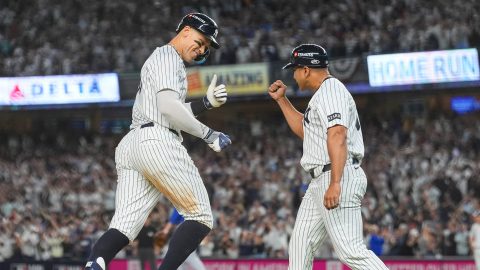New York Yankees' Aaron Judge celebrates with third base coach Luis Rojas after hitting a three-run home run against the Toronto Blue Jays during the fourth inning of Game 3 of baseball's American League Division Series, Tuesday, Oct. 7, 2025, in New York. (AP Photo/Yuki Iwamura)