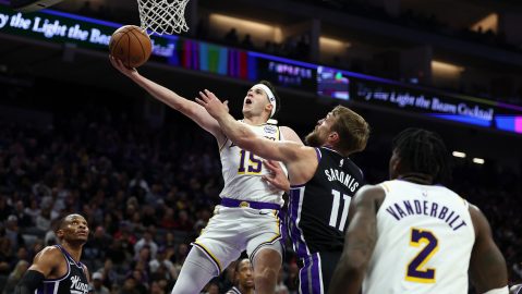 Austin Reaves, izquierda, de los Lakers de Los Ángeles, recibe una falta de Domantas Sabonis (11), de los Kings de Sacramento, durante la primera mitad del juego de baloncesto de la NBA, el domingo 26 de octubre de 2025, en Sacramento, California. (AP Foto/Sara Nevis)