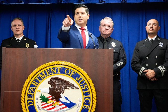 Acting U.S. Attorney Bill Essayli, middle, gestures while speaking during a news conference announcing an arrest made in the Palisades Fire, Wednesday, Oct. 8, 2025, in Los Angeles. (AP Photo/Damian Dovarganes)