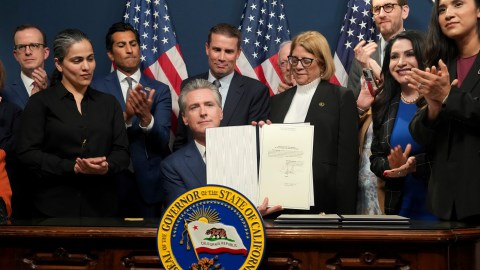 Gov. Gavin Newsom displays legislation he signed calling for a special election on a redrawn congressional map on Thursday, Aug. 21, 2025, in Sacramento, Calif. (AP Photo/Rich Pedroncelli)