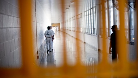 FILE - In this March 3, 2011 file photo, a guard looks on, at right, as prisoners move through the state prison in Jackson, Ga. After years of middling progress, Georgia lawmakers could soon adopt reforms to overhaul the state's clogged, and expensive, prison system. (AP Photo/David Goldman, File)