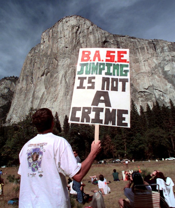 A protestor holds a sign in front of El Capitan in Yosemite, Calif., National Park before skydiver Jan Davis, 60, died after attempting to parachute Friday, Oct. 22, 1999. The skydivers jumped in a protest against the policy of skydiving in Yosemite. The organization "It's Our Park Too!" and the National Park Service worked out an agreement for several skydivers to jump Friday. (AP Photo/Paul Sakuma)