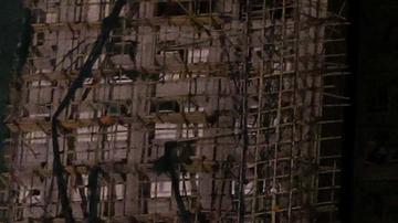 Una pareja mira los edificios calcinados en el distrito de Tai Po.