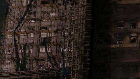 Una pareja mira los edificios calcinados en el distrito de Tai Po.