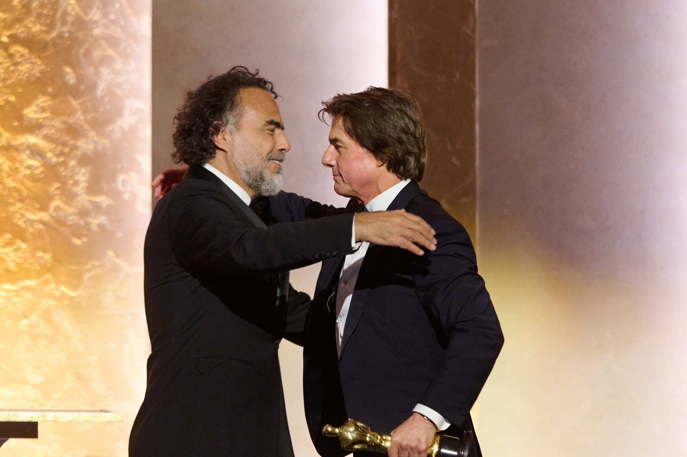 Alejandro González Iñárritu y Tom Cruise se abrazan sobre el escenario de los 16 Governors Awards.