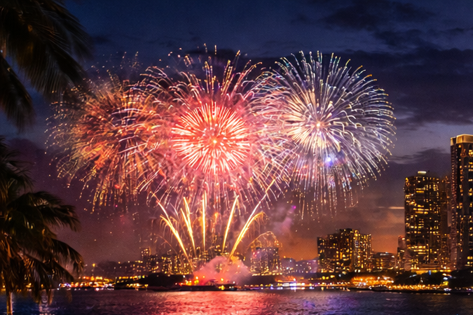 Concierto y fuegos artificiales de Año Nuevo en Bayfront Park con público frente a la Bahía de Biscayne.