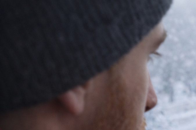 Hombre usando ChatGPT en su celular dentro de un auto durante una tormenta de nieve en Estados Unidos