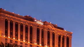 Las Vegas Strip al atardecer con hoteles iluminados y tráfico en la avenida principal
