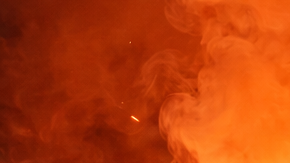 Ilustración generada con inteligencia artificial que muestra una bengala encendida en un espacio cerrado con presencia de humo y personas expuestas al riesgo.