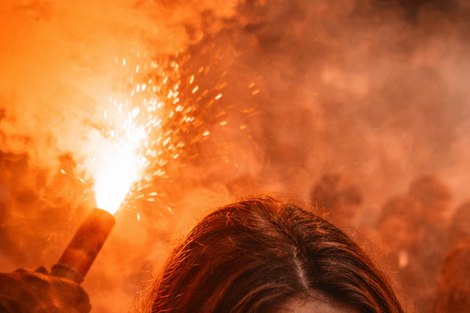 Ilustración generada con inteligencia artificial que muestra humo tóxico de una bengala en un espacio cerrado y personas afectadas por la inhalación.